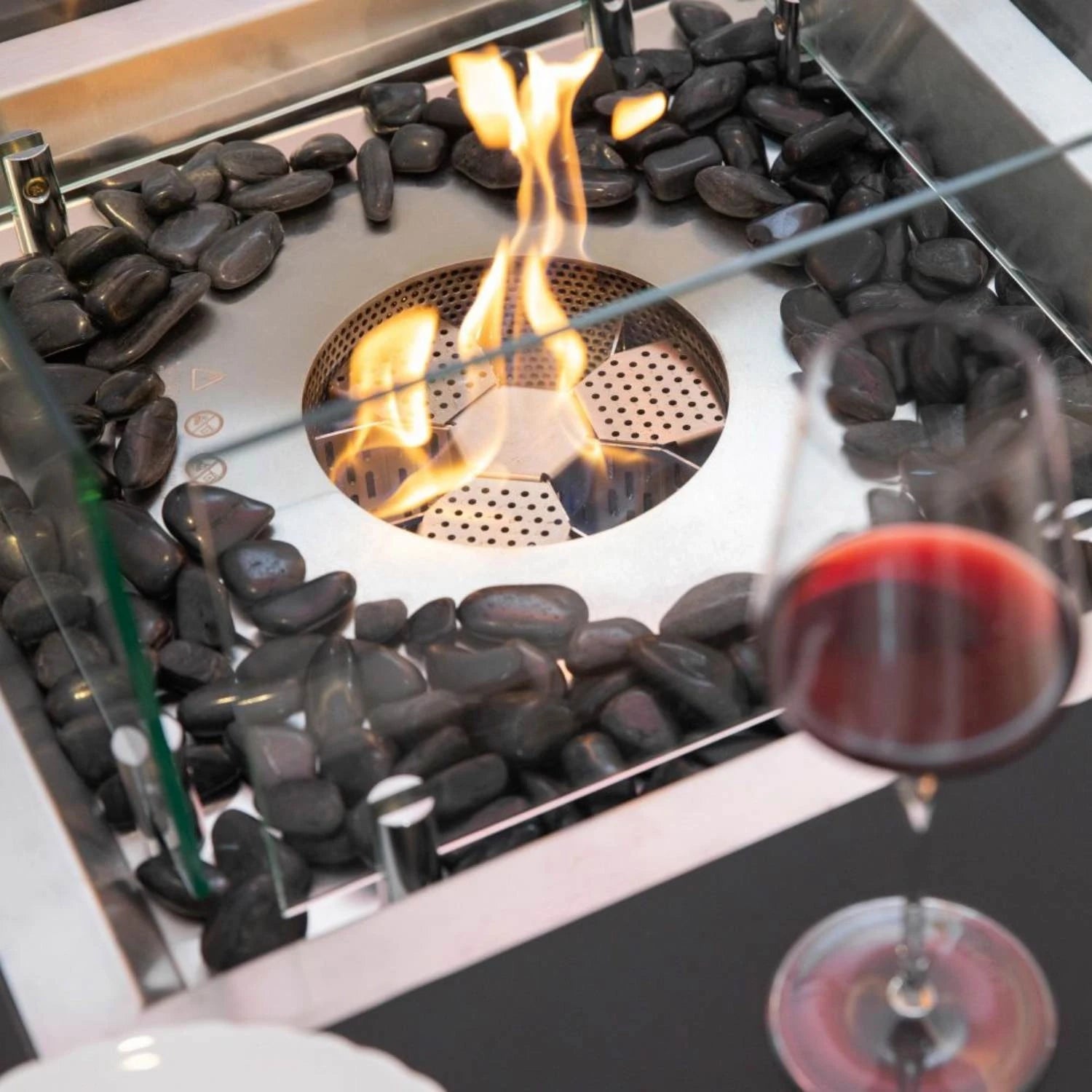 Aurora bioethanol fire pit in matte black with glass windscreen and bronze fire glass