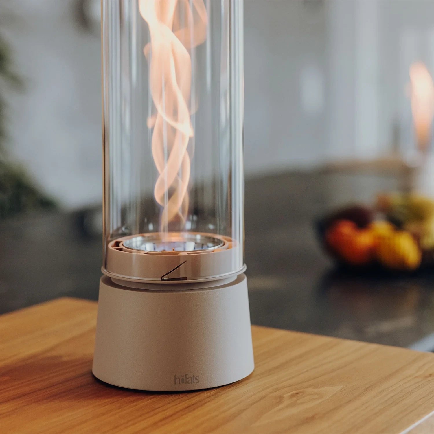 Höfats SPIN Air 1200 - Sand-colored tabletop bioethanol fireplace with tall cylindrical glass.