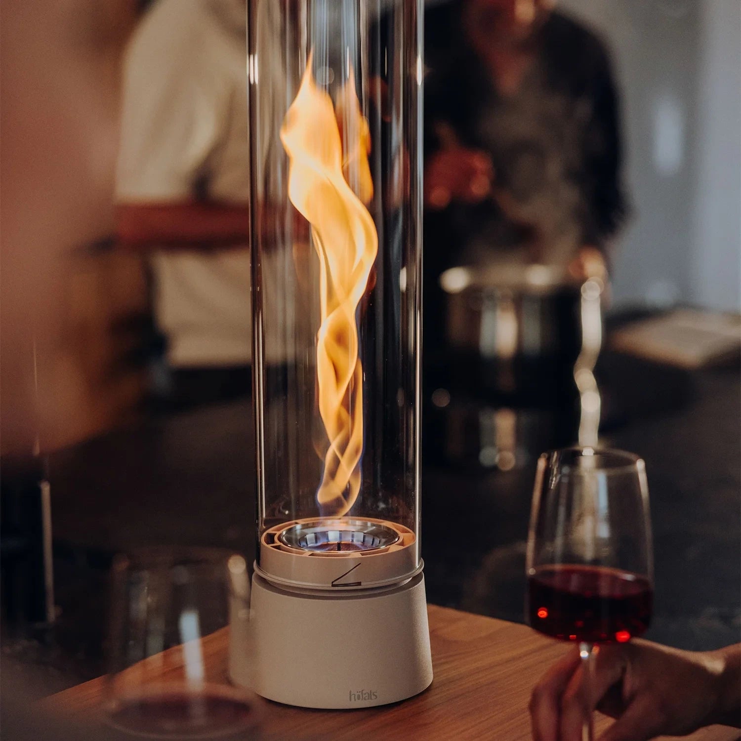 Höfats SPIN Air 1200 - Sand-colored tabletop bioethanol fireplace with tall cylindrical glass.